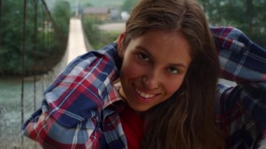 Gezgin suratlı, gülümseyen kamera dışarıda. Mutlu kız nehirde doğanın tadını çıkarıyor..