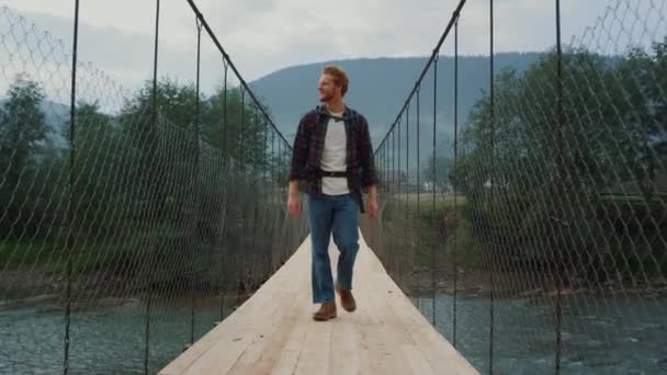 川の橋の山の上で手を振ってトレッキング旅行者屋外. — ストック動画