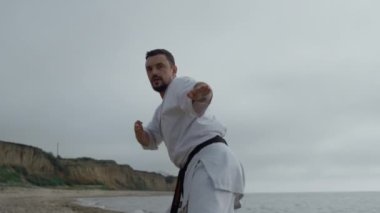 Kumsalda karate dövüşü antrenmanı. Dövüş sanatları öğrenen adam.