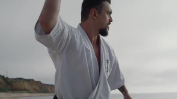 Kungfu man practicing martial arts on beach close up. Karate fighter workout. — Stock Video