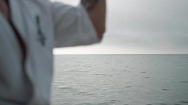 Unknown athlete learning karate technique close up. Man workout summer morning.
