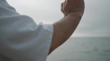 Unknown sportsman hands practicing karate position. Strong man training strength
