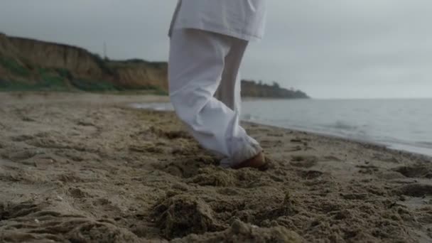 Man feets stepping on beach sand practicing karate overcast weather close up. — Stockvideo