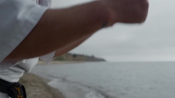 Man vuist training karate stoten op het strand close-up. Atleet die oefeningen doet. — Stockvideo