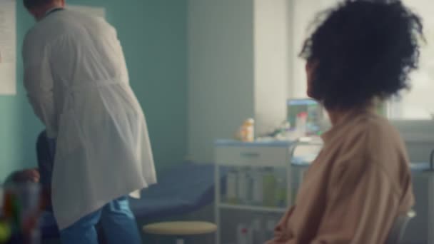 Kinderärztliche Beratung Teenagermädchen in Anwesenheit der Mutter. Arzt untersucht Kind. — Stockvideo