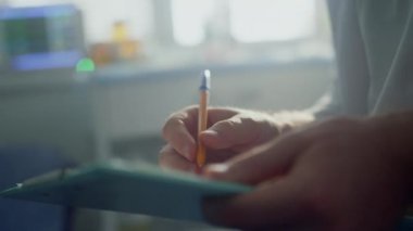 Doktor elleri hasta kayıt formunu dolduruyor. Kapatın. Hekim not alıyor.