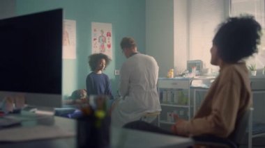 Teen girl visit doctor office with mother. Man physician checkuping preteen.