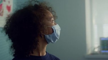 Hekim, Afro-Amerikan kız için hastanede aşı hazırlıyor..