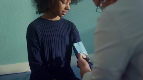 Doctor checking arterial pressure using tonometer on african girl arm close up. — Wideo stockowe