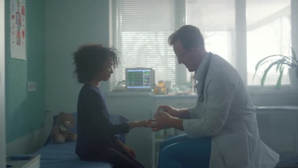 Pediatra usando oxímetro comprobando saturación de oxígeno en dedo de niña de cerca. — Vídeos de Stock