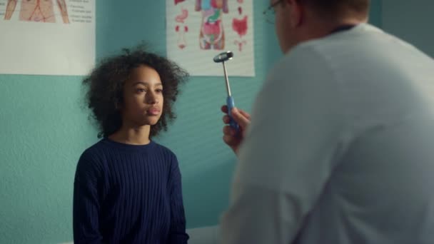 Teen girl visit neurologist in modern clinic close up. Doctor testing eye reflex — Vídeos de Stock