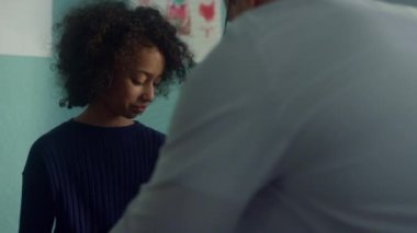 Doktor çocuk kolunda tonometre kelepçe kullanıyor. Genç kız muayenesi. Yakın çekim.. 