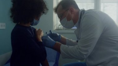 Klinikte aşırı dozda covid aşısı alan bir kız. Doktor iğne yapıyor..