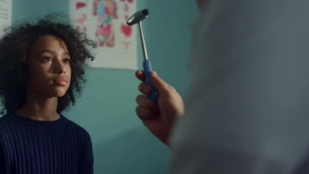 Neurologist checking visual reflex african american teen kid in modern clinic. — Vídeos de Stock