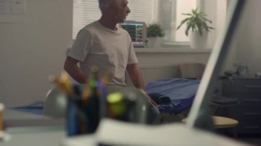 Doktor yaşlı adama enjekte etmeden önce aşının dozunu kontrol ediyor. Klinikte dokunulmazlık