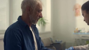 Klinikte kıdemli doktor muayene ediliyor. Doktor basıncı ölçüyor..