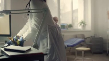 Hastanedeki hastaların basıncını ölçmek için tonometre steteskobu alan doktor.