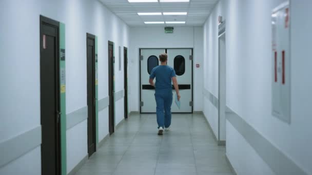 Chirurg im Operationssaal Rückansicht. Arzt läuft auf Krankenhausflur — Stockvideo