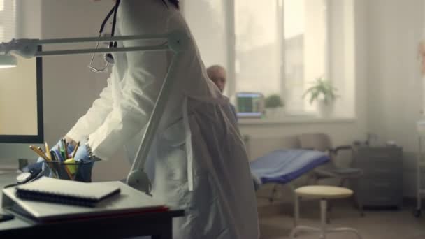 医生用听诊器测量坐在医院里的压力病人 — 图库视频影像