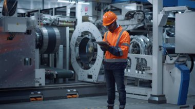 Modern fabrikada mühendis görünümlü tablet ekran. Üretim tesisi kavramı.