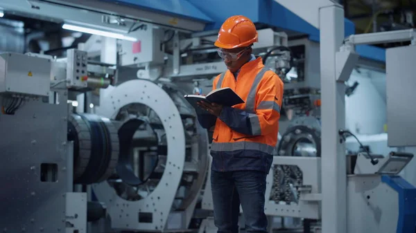 Male engineer taking notes of project data at manufacturing factory. — Fotografia de Stock