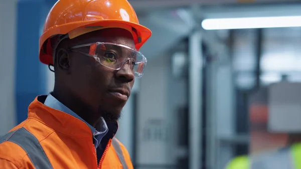Man engineer shaking head wearing safety uniform at modern factory closeup
