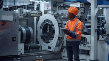 Afrikalı Amerikalı mühendis veri endüstriyel fabrikası çalışmalarını tesis üzerinde analiz ediyor.