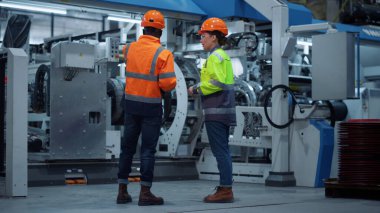 Modern makine fabrikasında çalışan odaklanmış yöneticiler. Üniformalı iş adamları