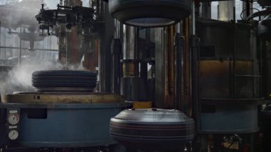 Otomotiv atölyesinde çalışan mekanik lastik üretim makinesi.