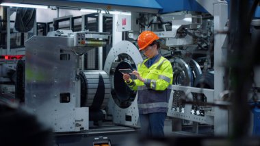 Endüstriyel üretim fabrikasında şeffaf tablet bilgisayar tutan bir mühendis..