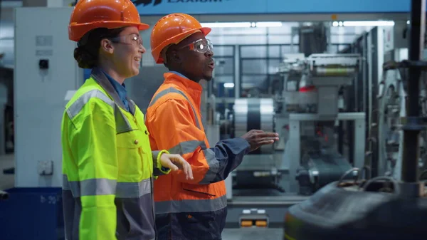 Les superviseurs parlent usine moderne portant l'uniforme de sécurité ensemble. Travail d'équipe — Photo