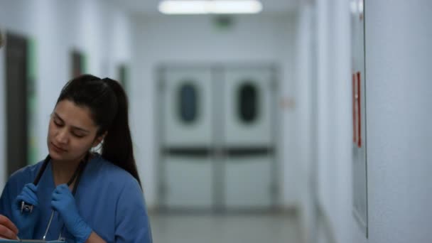 Indian woman doctor consulting man surgeon in hospital corridor close up. — Stock videók