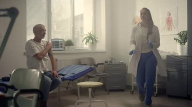 Sağlık kliniğinde yaşlı hasta aşısına danışmanlık yapan melez bir doktor.