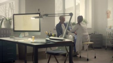 Doktor, yaşlı hastanın koluna kelepçe takıyor. Sağlık hizmetleri kavramı.