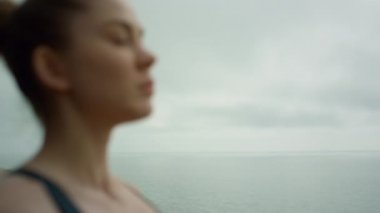 Etkileyici kadın bulutlu günü kapatıyor. Deniz kıyısında meditasyon yapan kız.