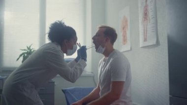 Nurse taking saliva sample from patient. Woman doctor collecting tests covid19.