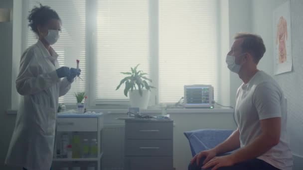 Doktor dělá testy na pacientovi v kancelářské nemocnici. Sestra odebírá vzorek od muže. — Stock video