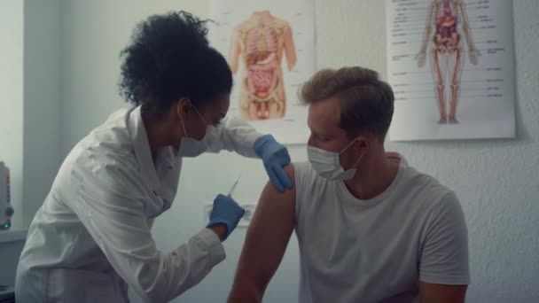 Médico que hace la inyección de vacuna en el hombro del hombre. Médico vacunando al paciente. — Vídeo de stock
