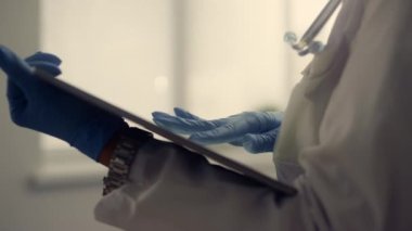 Doktor elleri tablet ekranı kapatıyor. Bilinmeyen doktor tutacağı.