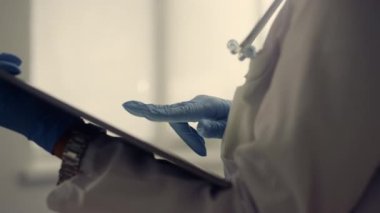 Physician hands holding pad computer checking patient data in hospital close up.