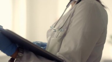 Doctor woman using tablet computer in clinic close up. Portrait lady physician.