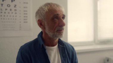 Portrait senior man visit therapist in hospital. Woman doctor typing on tablet.