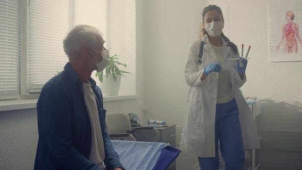 Latino médecin collecte échantillon de salive senior homme gros plan. Concept de test Covid. — Video
