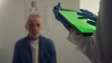 Yeşil ekran tableti doktor ellerine değiyor. Ped bilgisayar kullanan bir terapist