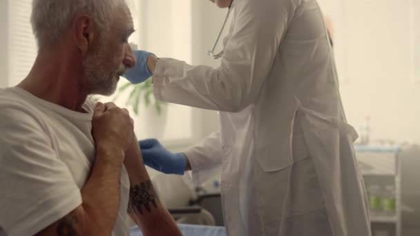 Doktershanden injecteren geestig vaccin oude man van dichtbij. Artsen steriliseren arm. — Stockvideo