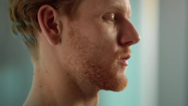 Serious man face expression closeup. Tired ginger worker resting after hard day — Stockvideo