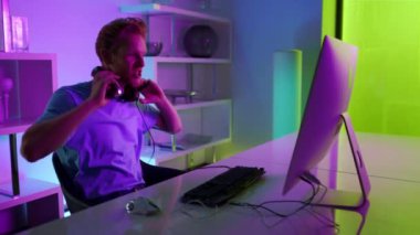 Cyber game winner enjoying success in neon room. Excited student rest on weekend