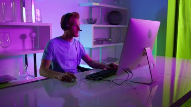 Neon player enjoy gaming tournament. Focused streamer blogger recording game — стоковое видео