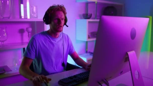 Esport-Profi spielt zu Hause in Neon-Licht-Nahaufnahme. Frustrierter Ingwermann — Stockvideo