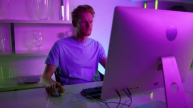 Neon Adam evde çalışan bilgisayar ekranı gibi görünüyor. Odaklanmış oyuncu akşamın tadını çıkar